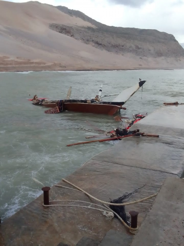 صور.. إعصار "تيج" يغرق ويدمر سفينتين خشبية في ميناء سقطرى 